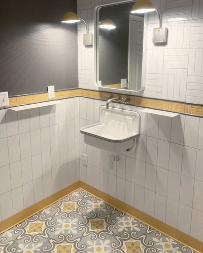 Match simple bathroom wall art with the beautiful yellow-gray vibrance of our classic Aline 4 cement tiles on the floor.
